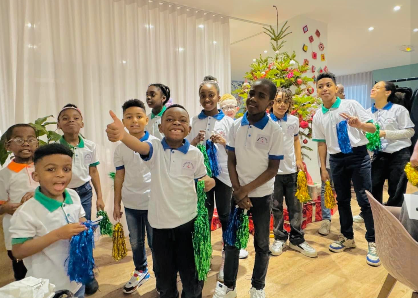 Enfants ivoiriens souriants tenant des livres, soutenus par l'association humanitaire chrétienne Akwaba Eden depuis Rennes